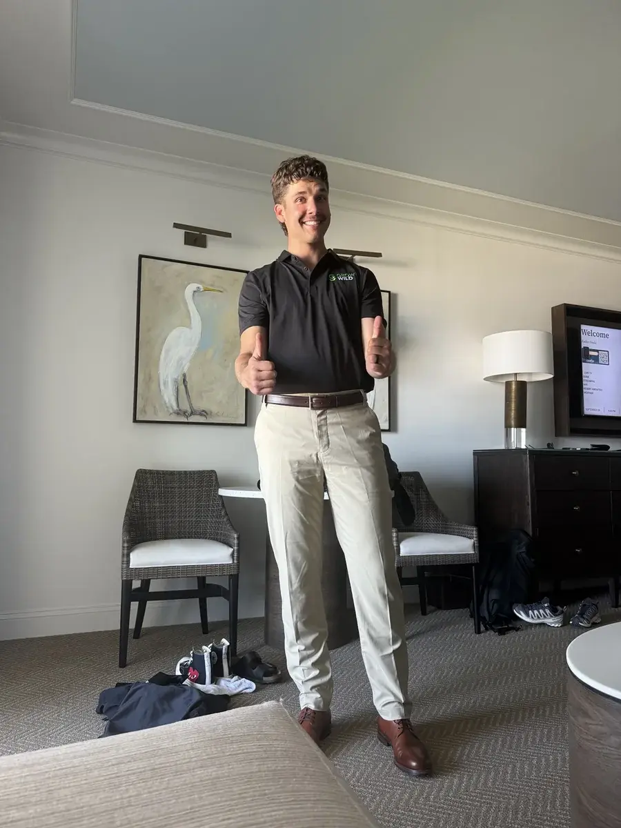 Kaden Ewald wearing a black Grow Wild polo and giving two thumbs up.